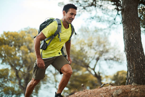 mid adult man cross-country running. - running jogging mountain footpath imagens e fotografias de stock