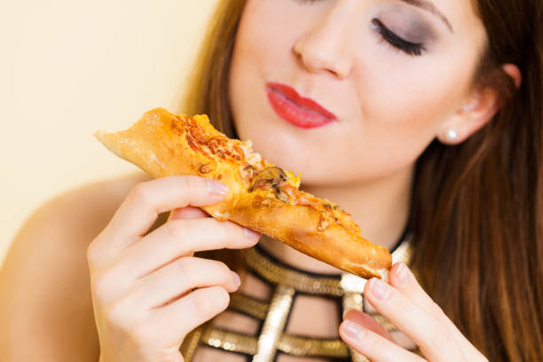 istock Woman eating hot pizza slice 1178343793