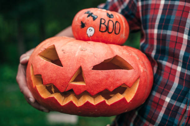 istock Man holding Halloween pumpkin and jack o' lantern 1178344872