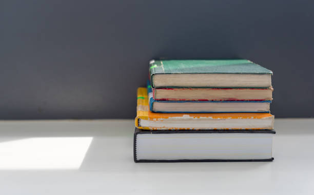istock Books stacked on the table in library at university in selective focus. 1178345088