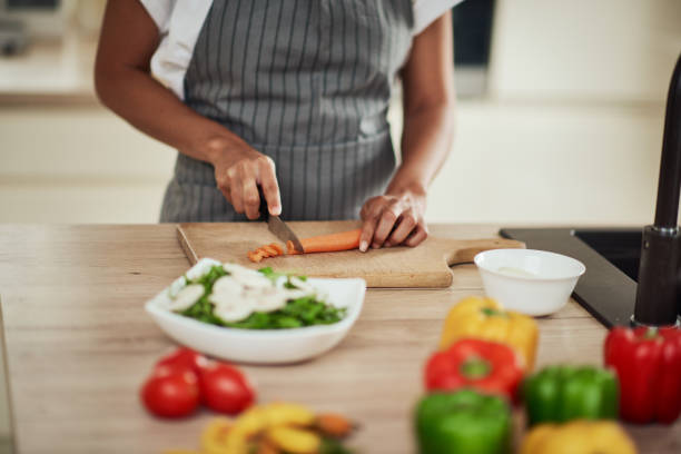 istock Woman cutting carrot in kitchen at home. 1178345127