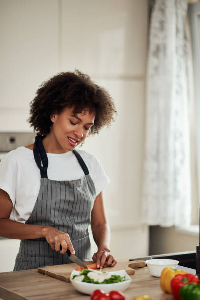 istock Woman cutting carrot in kitchen at home. 1178346203