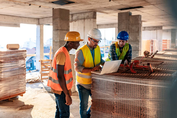 Workers at construction job site inside building Engineer, architect and business man working on the engineering project at construction site. House building concept. Photo of young male architect engineer using laptop computer. foreman stock pictures, royalty-free photos & images