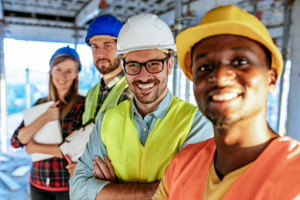 team von ingenieuren auf der baustelle posiert und schaut in die kamera - horizontal female with group of males posing looking at camera stock-fotos und bilder