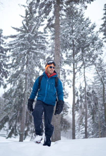 istock Smiling diverse couple holding Christmas presents while walking through a winter forest 1178354485