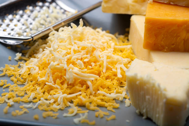 istock Cheese collection, matured and orange original British cheddar cheese in blocks and grated served on grey plate 1178358030