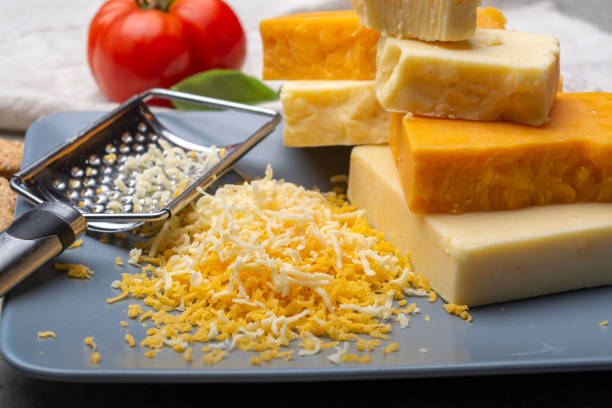istock Cheese collection, matured and orange original British cheddar cheese in blocks and grated served on grey plate 1178358043