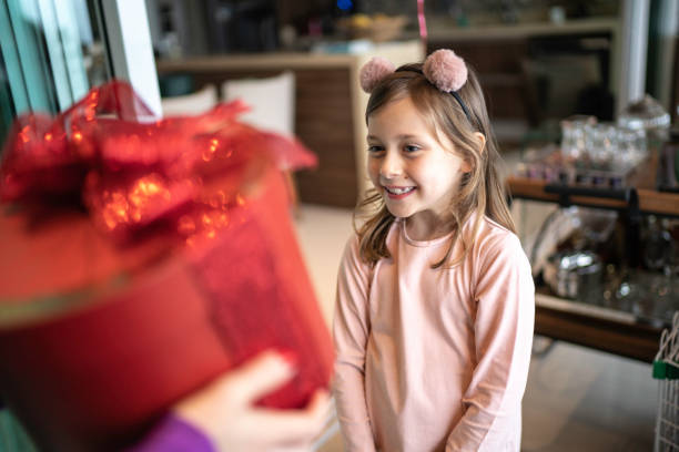 Young girl giving a gift box to a woman Young girl giving a gift box to a woman happy birthday cousin stock pictures, royalty-free photos & images