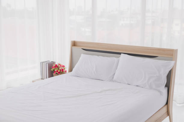 istock White bedroom interior with windows. Clean white bed and pillows in room. 1178360778