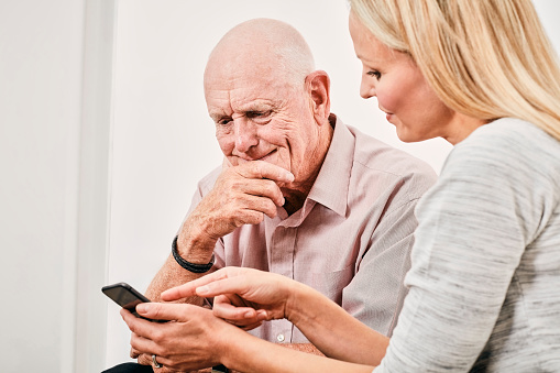 Daughter teaching Father how yo use mobile phone