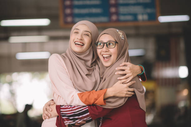 two muslim female malay ladies friend met up at wet market in the morning and greeting to each other two muslim female malay ladies friend met up at wet market in the morning and greeting to each other malay stock pictures, royalty-free photos & images