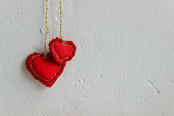 istock Valentine day banner. Two hearts hanging on a wall. Needlework. 1178366230