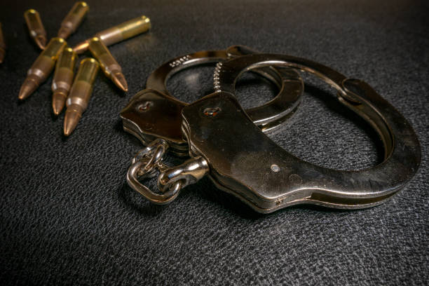 istock Handcuffs and ammo on a black table. Arms trade, crime concept 1178366278
