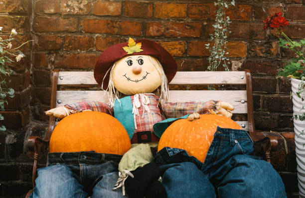 istock A rag scarecrow and two pumpkins in jeans are sitting on a bench. 1178368760