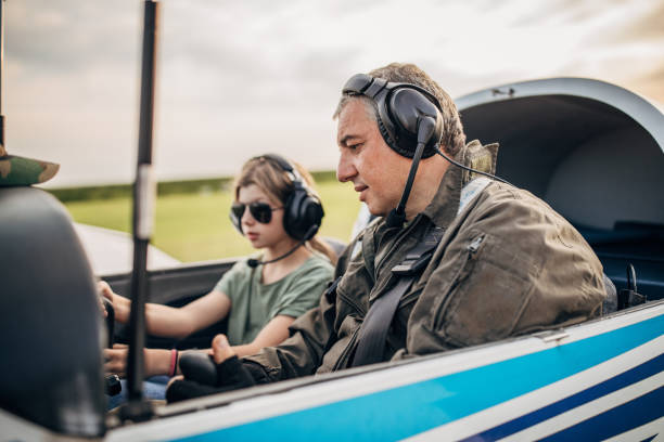 istock Daughter and father pilot sitting in airplane 1178369143