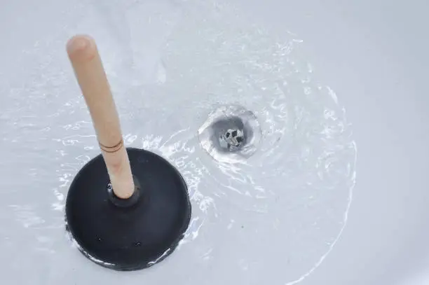 Photo of Plunger and clogged bath drain.