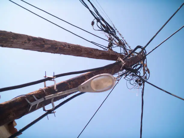 Loads of Powerlines and streetlamp on wooden poles