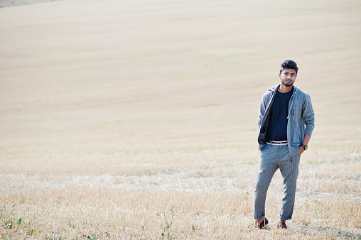 Indian man at casual wear posed at field alone.