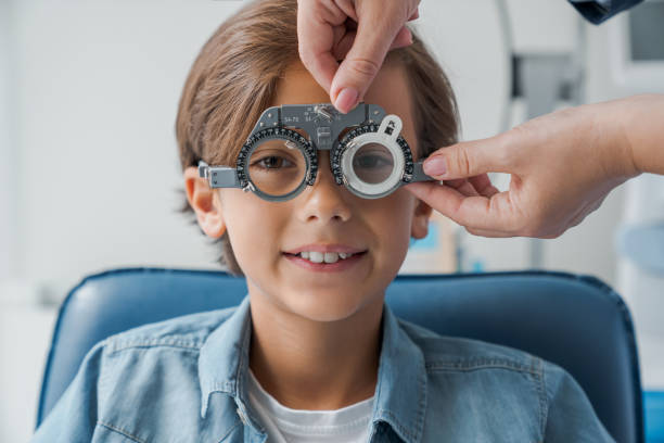 istock Young boy with phoropter during sight testing eye examinations in ophthalmological clinic. Optometry concept. 1178375218