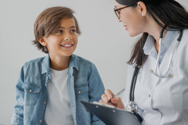 school boy and doctor have consultation in hospital room - medical exam fotos imagens e fotografias de stock