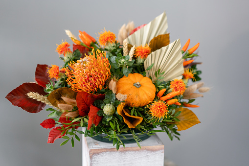 Autumn bouquet of mixed flowers on wooden table. The work of the florist at a flower shop. Fresh cut flower