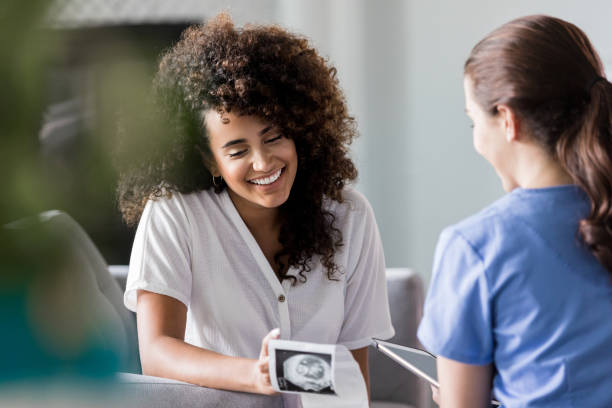 mujer embarazada emocionada mirando la imagen de la ecografía - ultrasound human pregnancy ultrasound machine doctor fotografías e imágenes de stock