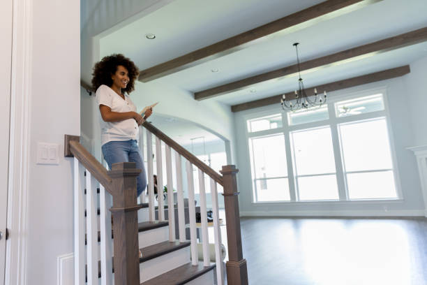 podekscytowana młoda kobieta na schodach w nowym domu - human pregnancy finance mixed race person holding zdjęcia i obrazy z banku zdjęć