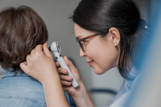 close up of doctor examining boy's ear with otoscope in medical cabinet - young ears imagens e fotografias de stock