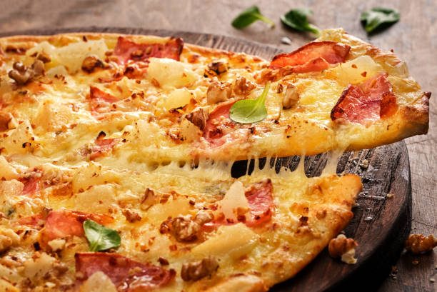 istock Tasty freshly prepared pizza with pear, nuts and bacon on a wooden board, rustic style 1178377190