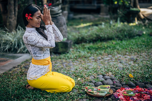 Woman in Prayer Position- offering for Gods. Balinese tradition.
