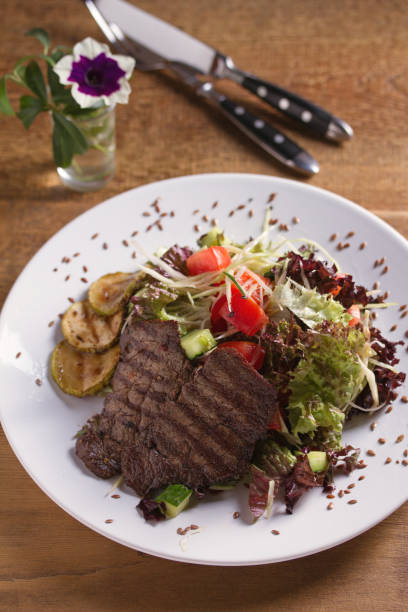 istock Beef salad: grilled beef steaks with tomatoes, cucumbers, zucchini, lettuce and cabbage, sprinkled with flax seeds 1178383609
