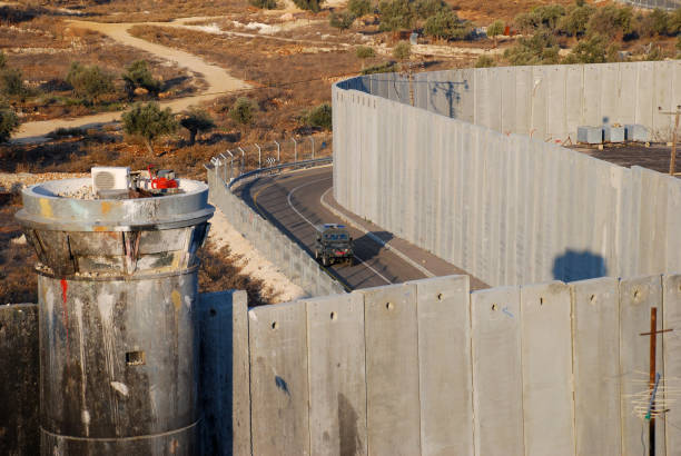 Israeli Security Barrier and border police jeep Israel's controversial separation/security barrier, here seen from a rooftop in the Palestinian refugee camp of Aida, in Bethlehem. An Israeli military vehicle stands watch in the center of the photo. bethlehem west bank stock pictures, royalty-free photos & images