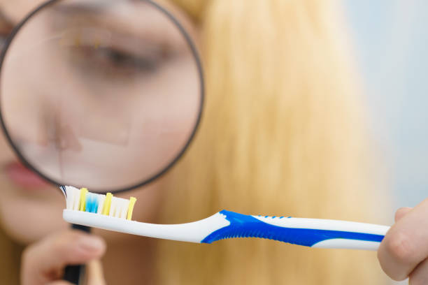 istock Woman looking at toothbrush through loupe 1178386571