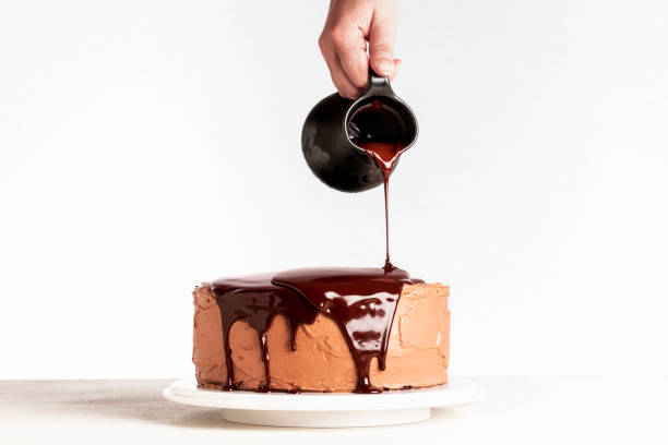 istock Pouring chocolate over layered cake. Dripping melted chocolate 1178386606