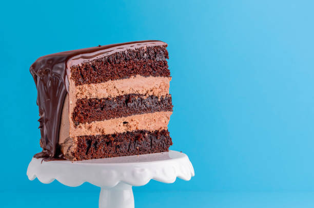 istock Chocolate birthday cake slice close-up on a white stand 1178386835
