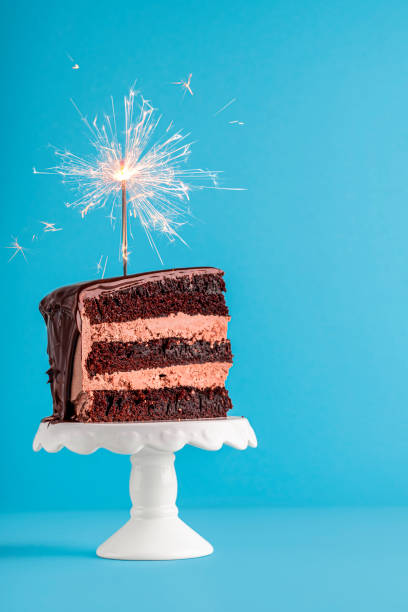 istock Chocolate cake slice with sparkler. Birthday cake on blue background 1178386927