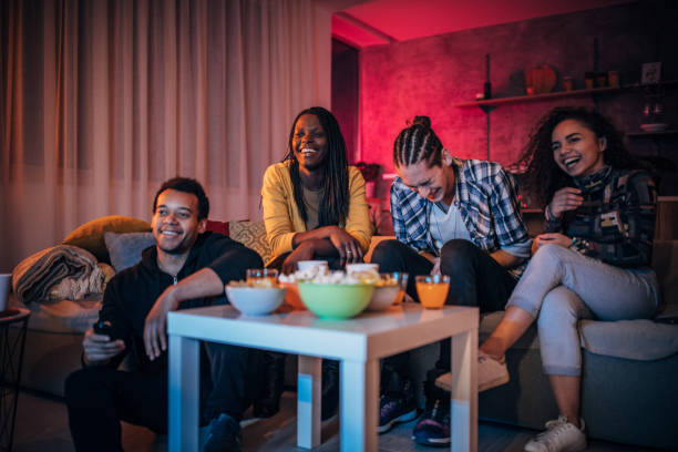 Multi-ethnic friends watching TV together Multi-ethnic friends watching TV together college dorm party stock pictures, royalty-free photos & images