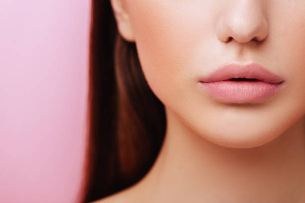 istock Lips of Beauty model with natural make up on pink background 1178390452
