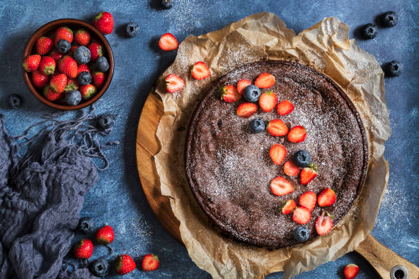 新鮮なベリー、イチゴ、ブルーベリーとスウェーデンの伝統的なチョコレートケーキクラッドカカ - baked brown cake circle ストックフォトと画像