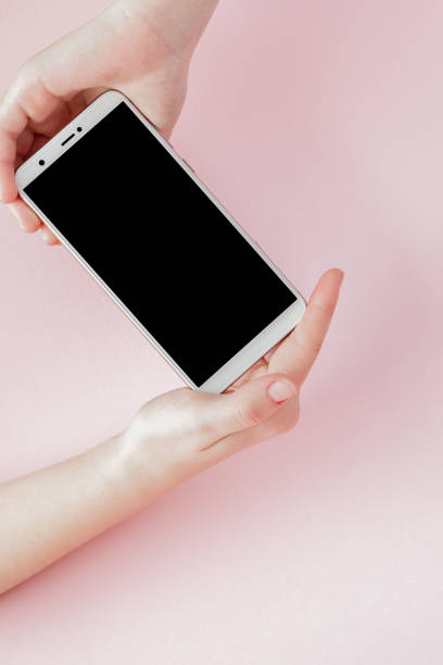 istock Modern mobile phone in a woman's hand on pink background 1178392546