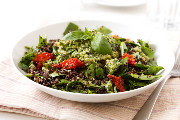 Quinoa Salad A Quinoa Salad with sun-dried tomatoes and pesto salad bowl photos stock pictures, royalty-free photos & images