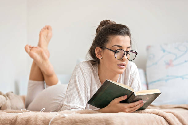 istock Woman reading book in bed 1178394341