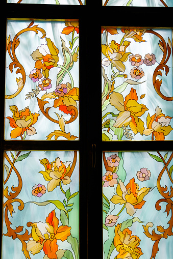 Old stained glass window with floral pattern in old cathedral
