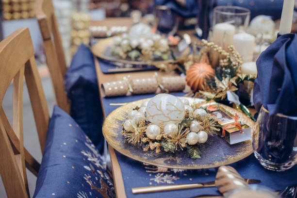 istock Christmastime table setting, festive dinnerware decorated with details and white balls in Blue and Gold colors. Navy Blue Table Linens and Gold Cutlery. Trends of Winter Holiday Tablescape Decor. 1178401762