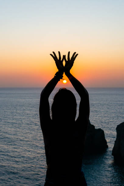 istock Silhouette young woman practicing yoga on the beach at sunset. 1178406605