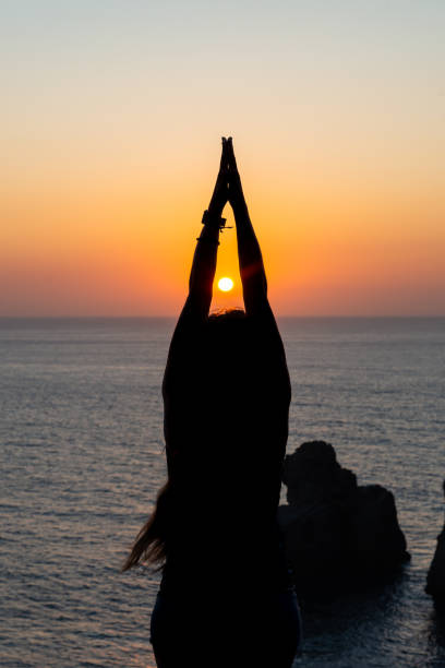 istock Silhouette young woman practicing yoga on the beach at sunset. 1178406608