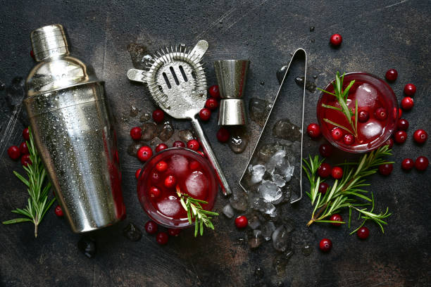 Winter christmas cocktail with cranberry and rosemary Winter christmas cocktail with cranberry and rosemary in a glasses on a dark slate, stone or concrete background. Top view with copy space. mint julep photos stock pictures, royalty-free photos & images