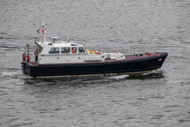 bateau de pilote de remorqueur quittant le port lentement - piloting commercial dock harbor industrial ship photos et images de collection