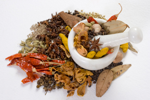 assorted spices isolated on a white background including bay leaves, cardamom pods, coriander seeds, cumin, star anise, cinnamon sticks, black peppercorns (spices for cooking cut out) indian cuisine