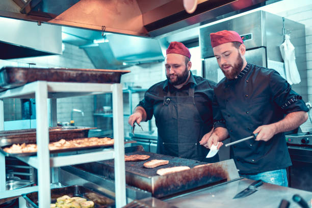istock Male Bakers Baking Grilling Bread And Roasting Potatoes 1178425353
